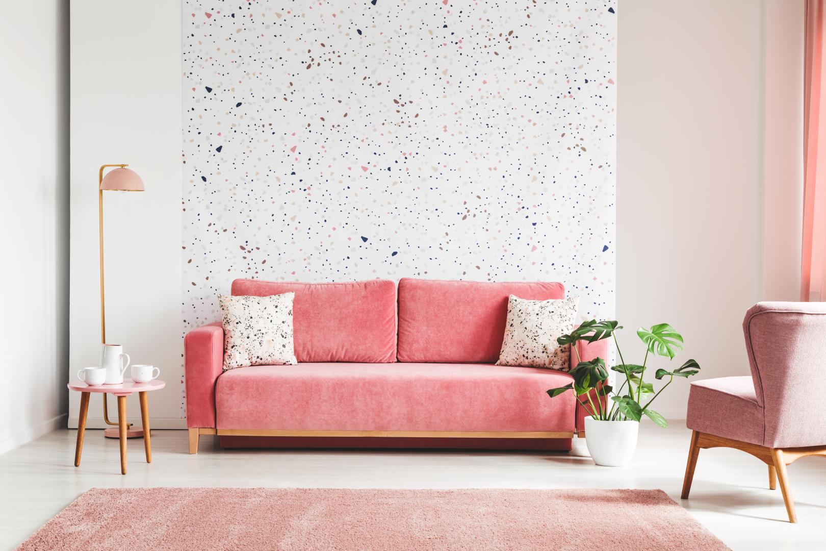 A bright living room with a pink sofa and a pink chair